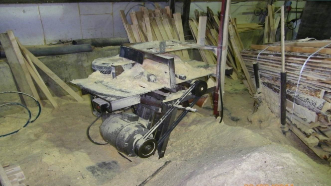 Bildē attēlots kokapstrādes aparāts.