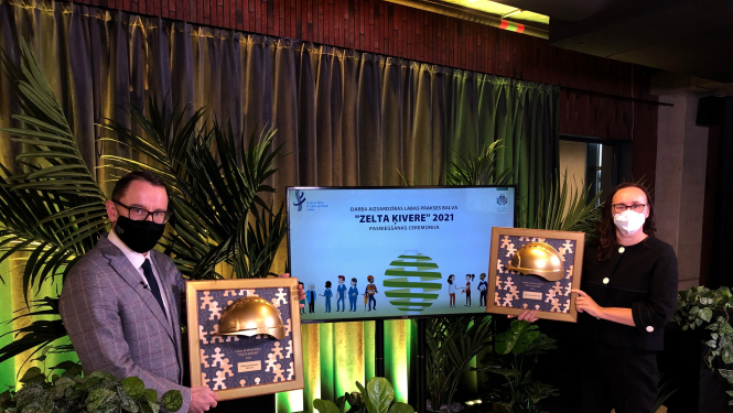 VDI Direktors kopā ar konkuras uzvarētāju prezentē balvu "Zelta ķivere"