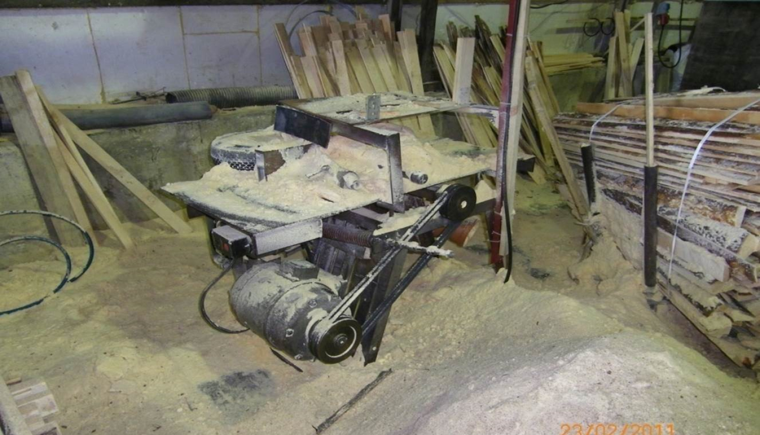 Bildē attēlots kokapstrādes aparāts.